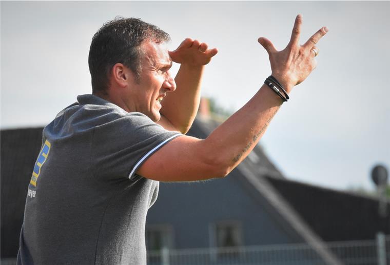 Trainer Chris Müller zeigt drei Finger in die Luft.