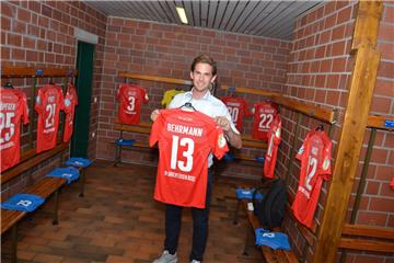 Drochtersen/Assel-Kapitän Sören Behrmann mit den Pokal-Trikot seiner Mannschaft. Er hat sich in dieser Woche Urlaub genommen, damit er den Presserummel bewältigen kann. 