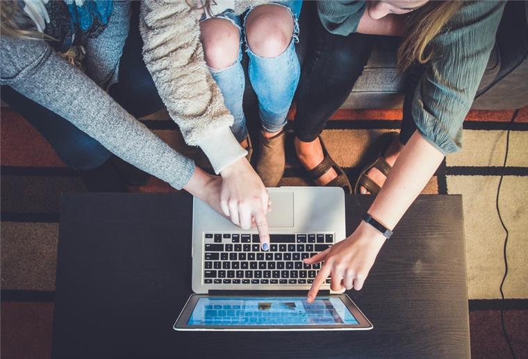 Schüler zeigen auf Laptop
