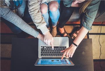 Schüler zeigen auf Laptop