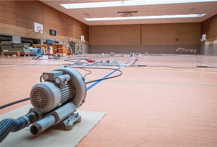 OSC-Mitarbeiter renovieren ihren Arbeitsplatz Durch den Grundwassereintritt muss seit rund drei Wochen der Boden der großen Sporthalle mit Elektrolüftern getrocknet werden.