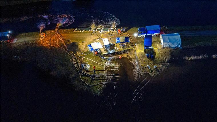 Ehrenamtliche Einsatzkräfte vom THW pumpen Wasser unweit der Aller.