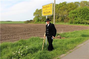 Eike Puschies geht auf die Walz: Die Wanderjahre beginnen, wenn er nach alter Tradition über das Ortsschild klettert.