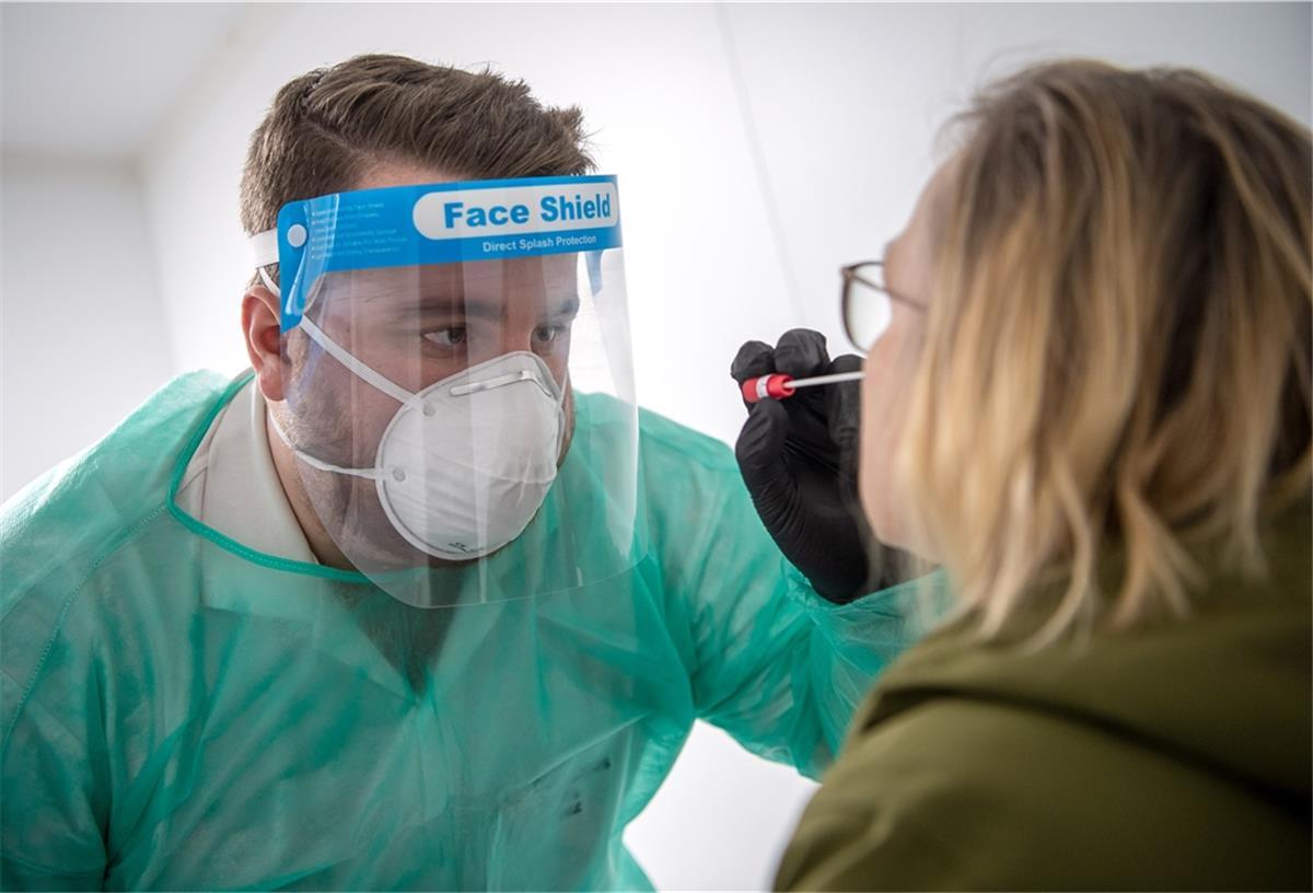 RKI: Zahl der Infektionen steigt wieder Ein Abstrich für einen PCR-Test wird von einem Mitarbeiter im Corona-Testzentrum genommen.