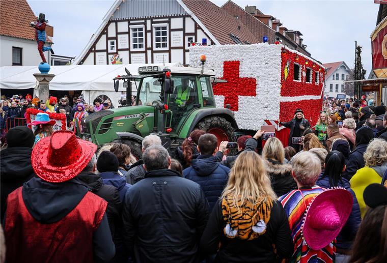 Dinosaurier, Elvis und Co. stürmen das Wahllokal! Ein als Krankenwagen geschmückter Karnevalswagen fährt beim Straßenkarnevalsumzug des Dammer Carnevals an der Statue des Dammer Narren (l) vorbei.