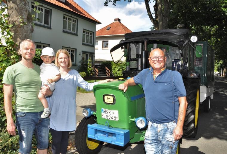 Ein alter Trecker in der Nordenhamer Lutherstraße. Daneben stehen Manfred Liboschik (rechts), sein Neffe Thorsten Riekes sowie dessen Frau Theda und Sohn Michel.