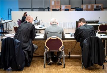 Ein Angeklagter (Mitte) sitzt im Gerichtssaal in der Weser-Ems-Halle auf einem Stuhl.