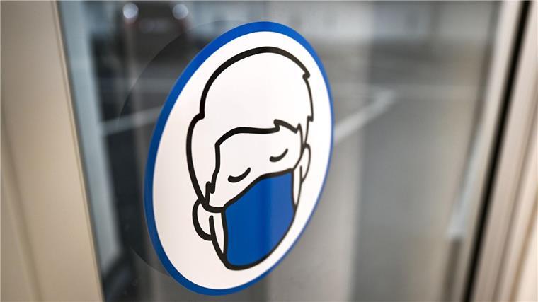 Corona: Wieder Maskenpflicht in einzelnen Kliniken - Reinkenheide geht eigenen Weg Ein Aufkleber an einer Glastür weist auf das Tragen einer Maske hin.