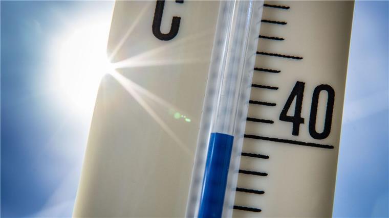 Apotheker: Gefahr von Hitzschlag und Sonnenstich wächst Ein Außenthermometer zeigt vor dem blauen Himmel und der Sonne eine Temperatur von nahezu 40 Grad Celsius an.