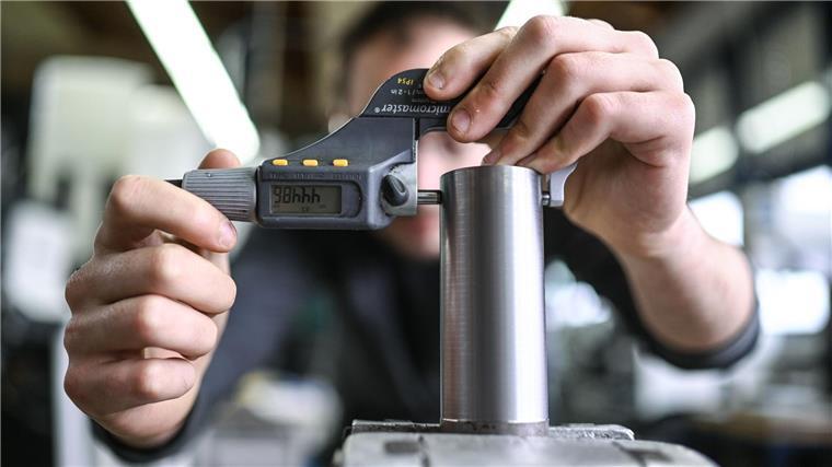 Umfrage: Zufriedenheit der Azubis wächst Ein Auszubildender im Metall-Handwerk misst in einem Ausbildungszentrum die Dicke eines Werkstücks.