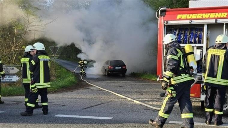 Feuerwehrmänner löschen einen Autobrand.  Ein Auto brannte am Dienstag in Drangstedt. Es kam zu Verkehrsbehinderungen auf der Landesstraße 120 durch Löscharbeiten.