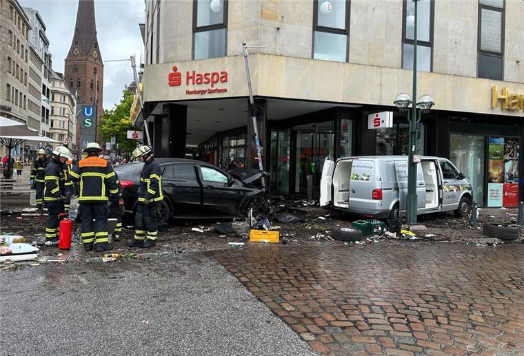 Hamburg: Auto rast über Gehweg am Jungfernstieg - ein Toter Helfer stehen an einem demolierten Auto vor einer Sparkasse. Ein Auto ist in Hamburg in eine Sparkasse gefahren, es gab mehrere Verletzte