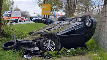 Ein Auto liegt nach einem Unfall auf dem Dach, während Rettungskräfte im EInsatz sind.
