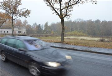 Ein Auto passiert das seit Jahren umstrittene Grundstück an der Bremer Landstraße in Tarmstedt. Dort befand sich einst ein Kalksandsteinwerk, Reste der Betriebsgebäude sind links im Hintergrund auf einem benachbarten Grundstück zu erkennen.