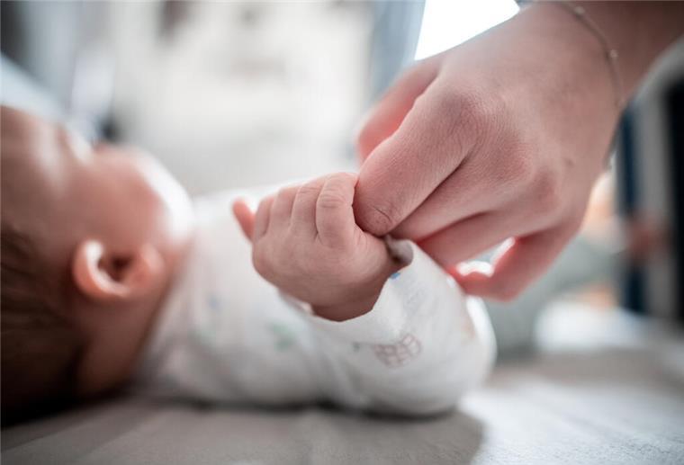 Neuer Platz 1: Das sind die beliebtesten Vornamen in Deutschland Ein Baby klammert sich an den Finger seiner Mutter.