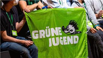 Ein Banner der Grünen Jugend wird von Teilnehmern auf einem Kongress gehalten.