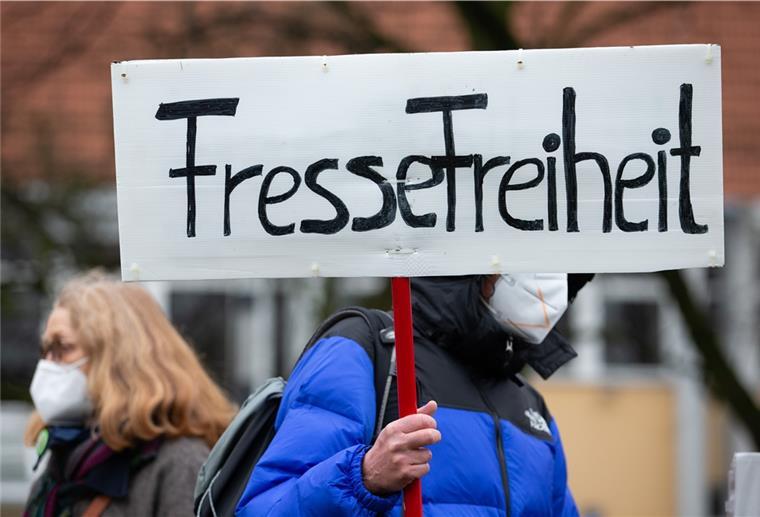 Ein Banner "Fressefreiheit" (in Anlehnung an "Pressefreiheit") wird von einem Teilnehmer einer Demonstration gehalten. Die Teilnehmer demonstrieren gegen die Corona-Politik.