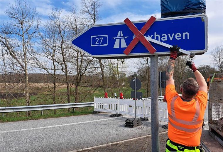 Die A27 ist wieder freigegeben - Camping-Rentner dürfen als Erste Ein Bauarbeiter entfernt das Gesperrt-Zeichen in Richtung Cuxhaven.