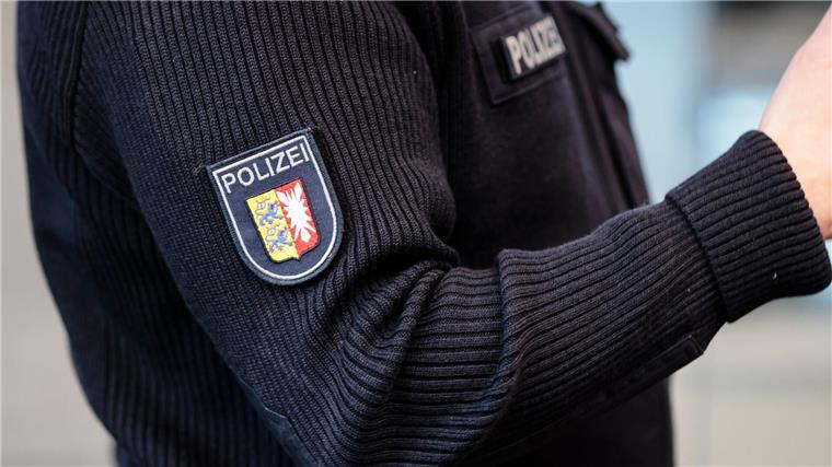 Ein Beamter trägt einen Pullover mit dem Wappen der Polizei Schleswig-Holstein.