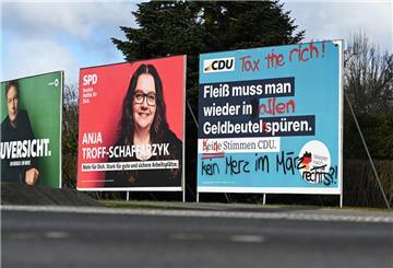 Ein beschmiertes Wahlplakat der CDU (r) steht an einer Straße