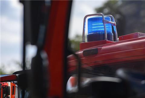Ein Blaulicht leuchtet auf dem Dach eines Einsatzfahrzeugs der Feuerwehr.