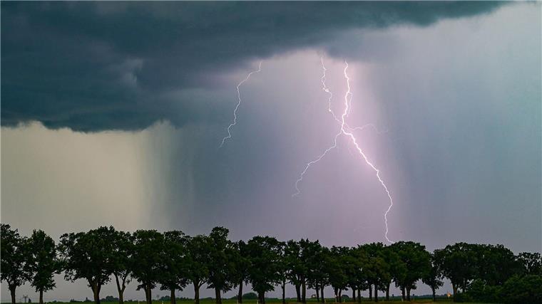 Mehrere Parks in Hannover wegen Unwetterwarnung geschlossen Ein Blitz leuchtet am späten Abend über der Landschaft.