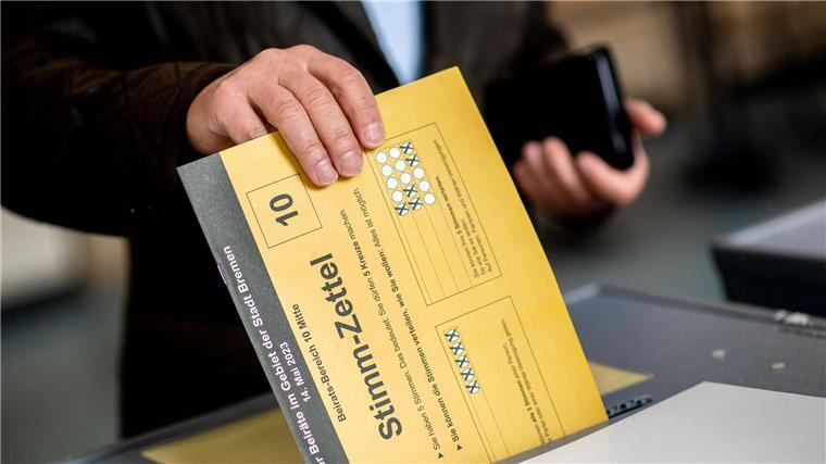 Stimmzettel in Bremerhaven müssen nicht neu gezählt werden Ein Bürger wirft in einem Wahllokal seinen Stimmzettel in eine Wahlurne.