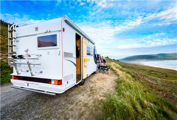 Wohnmobil parkt am Strand. Ein Check nach langer Fahrt – im Idealfall in der Fachwerkstatt – erhöht nicht nur die Sicherheit, sondern senkt auch das Risiko von Mängeln bei der Hauptuntersuchung.