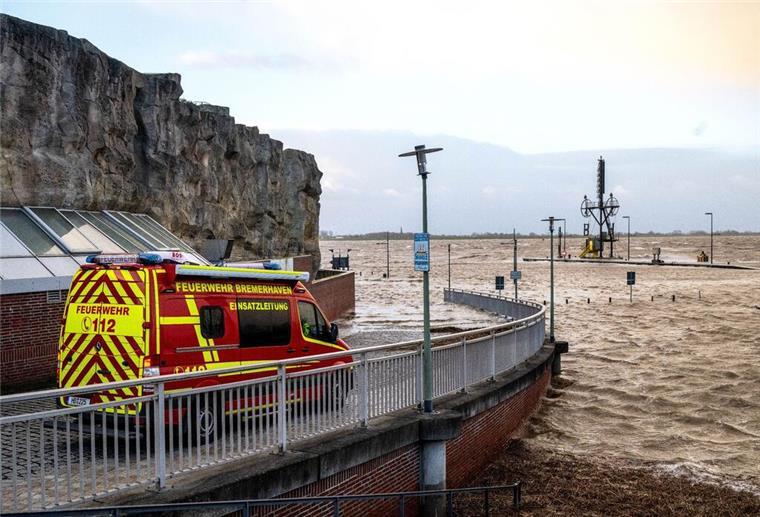 Feuerwehr: Hochwasser wird noch tagelang anhalten Ein Einsatzfahrzeug der Feuerwehr steht bei Sturmflut am Ufer der Wesermündung in Bremerhaven.