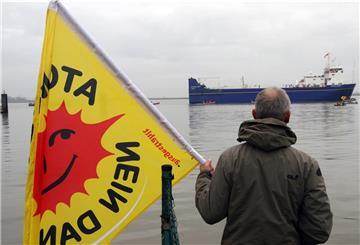 Ein einzelner Protestler steht beim letzten Atomtransport über Nordenham im Jahr 2011 am Weserufer.