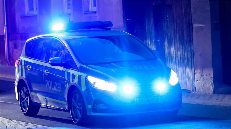 Unbekannte Täter sprengen Geldautomaten Ein Fahrzeug der Polizei fährt mit Blaulicht am Abend durch eine enge Straße.