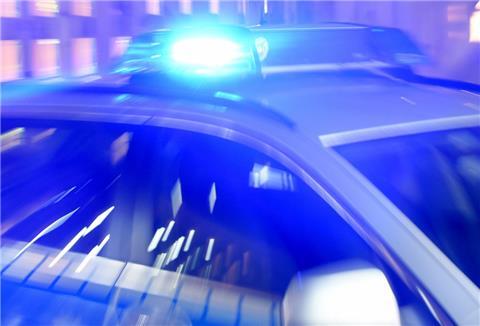  Ein Streifenwagen der Bundespolizei steht mit eingeschaltetem Blaulicht in der Ausfahrt einer Garage. 