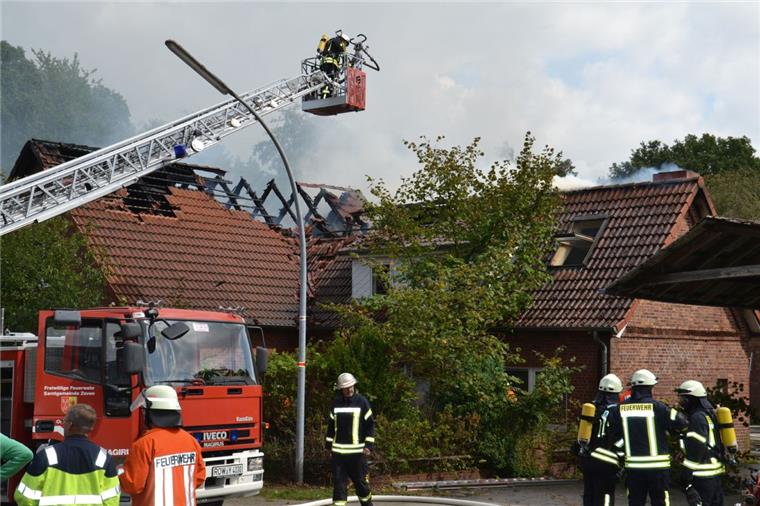 Wohnhaus in Brauel steht in Flammen Ein Feuerwehrmann öffnet von der Drehleiter aus das Dach, um die Flammen bekämpfen zu können.