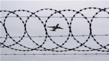 Ein Flugzeug startet am Flughafen Hannover - fotografiert durch Stacheldraht am Flughafenzaun.