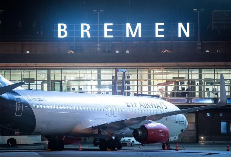 Grüne erwägen Ende der Passagierflüge ab Bremen Ein Flugzeug steht nachts auf dem Rollfeld vom Flughafen Bremen.