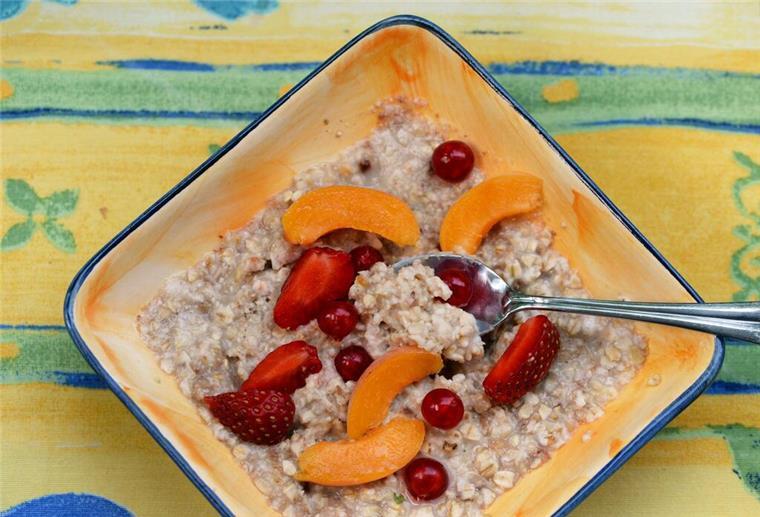 Gesundes Frühstück! Experte verrät - das gehört auf den Teller Eine Schale mit Porridge und Obst steht auf einem Frühstückstisch.