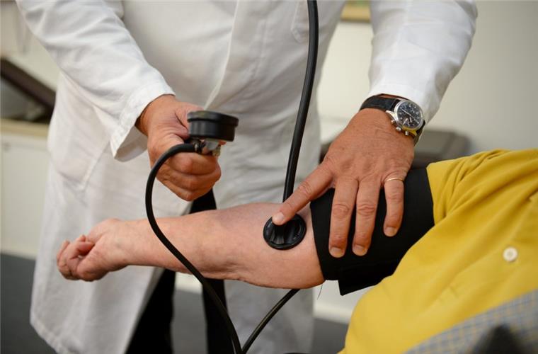 Ein Hausarzt misst in seiner Praxis einer Patientin den Blutdruck.   

Foto: Weissbrod/dpa