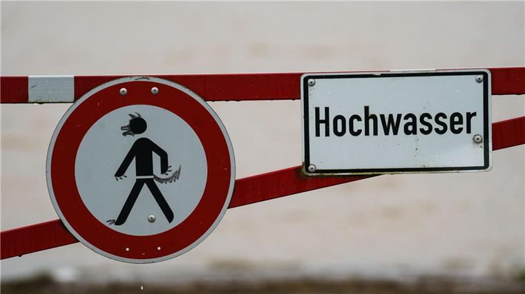 Landesbetrieb: Hochwasserlage verschärft sich über Feiertage Ein Hochwasser-Schild steht an einem überfluteten Feld.