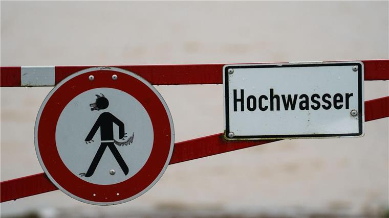 Mehrere Landkreise warnen vor Hochwasser Ein Hochwasser-Schild steht an einem überfluteten Feld.