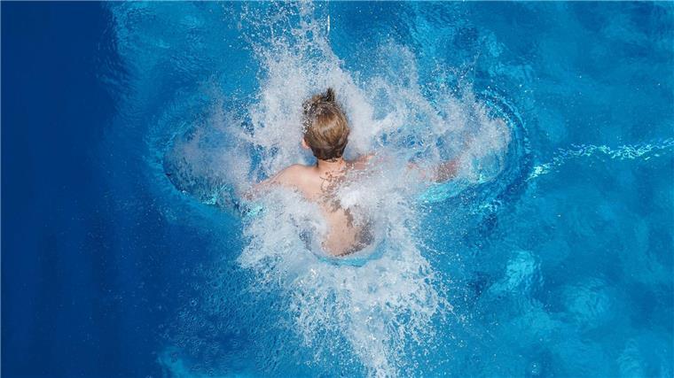Fünf Verletzte bei Chlorgasaustritt in Freibad Ein Junge springt in einem Freibad ins Wasser.