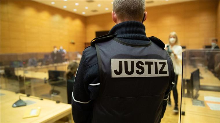 Drei junge Erwachsene wegen Kanaldeckel-Würfen verurteilt Ein Justizbeamter steht in einem Gerichtssaal.