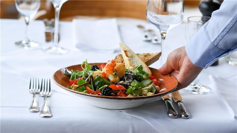 Gewerkschaft: Überlastung in Küchen und Gaststuben beenden Ein Kellner serviert einen Salatteller in einem Restaurant.