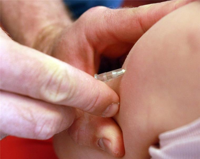 Masern-Impfung: Bundesregierung plant Geldstrafen und Kita-Ausschluss Ein Kinderarzt gibt einem Mädchen eine Masernimpfung.