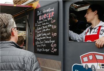 Ein Kunde betrachtet die Speisekarte an einem Food-Truck.
