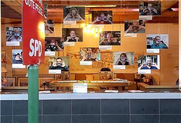 Bildern von lächelnden Menschen sind an einer Wand befestigt