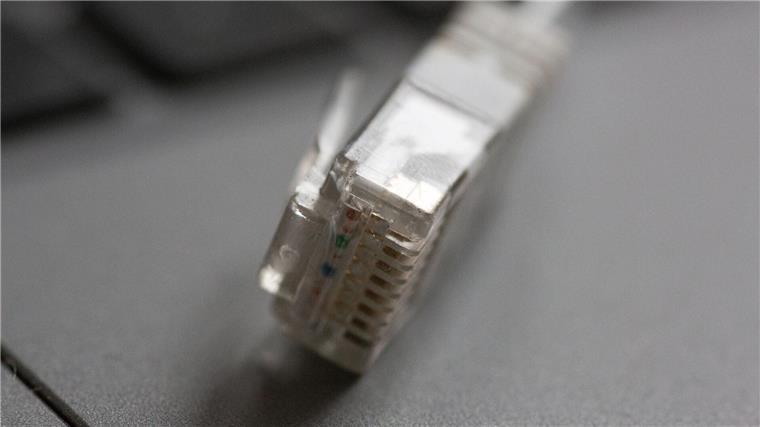 „Recht auf schnelles Internet“: Behörde schreitet ein Ein LAN-Kabel liegt auf einem Computerlaptop.