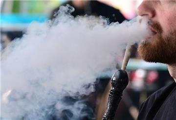 Ein Mann atmet Rauch aus, den er aus einer Shisha inhaliert hat (Symbolbild).