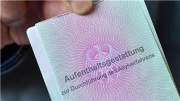 Ein Mann aus Syrien zeigt in der Gemeinschaftsunterkunft für Flüchtlinge seine Aufenthaltsgestattung.