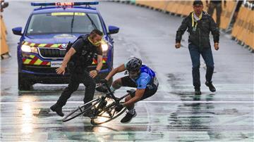 Ein Mann fährt bei der Tour de France unerlaubt über die Strecke. 
