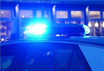 Ein Streifenwagen der Polizei steht mit eingeschaltetem Blaulicht an einem Einsatzort. 